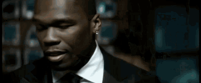 a man in a suit and tie is looking at the camera .
