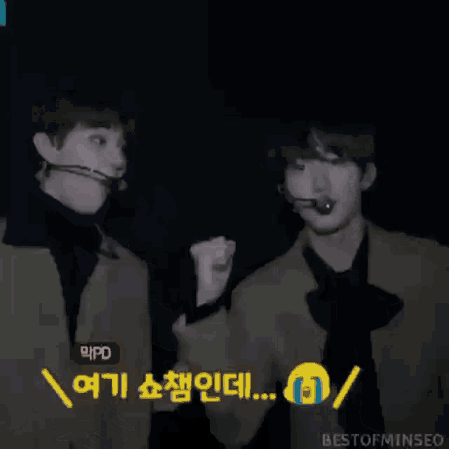 two young men are standing next to each other and one has a microphone in his mouth and the other has a microphone in his hand