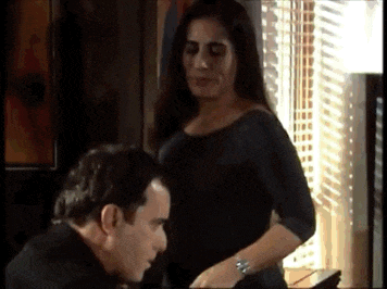 a man and a woman are standing in front of a window