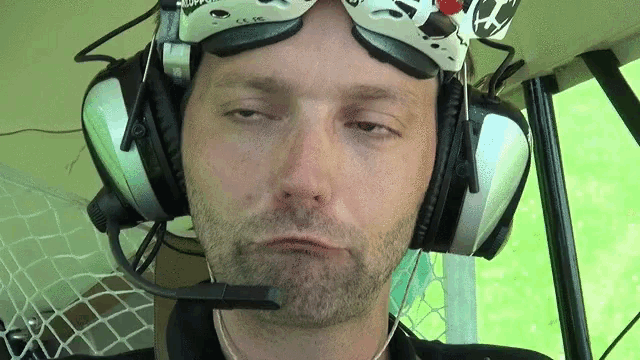 a man wearing a pair of goggles and headphones is making a face