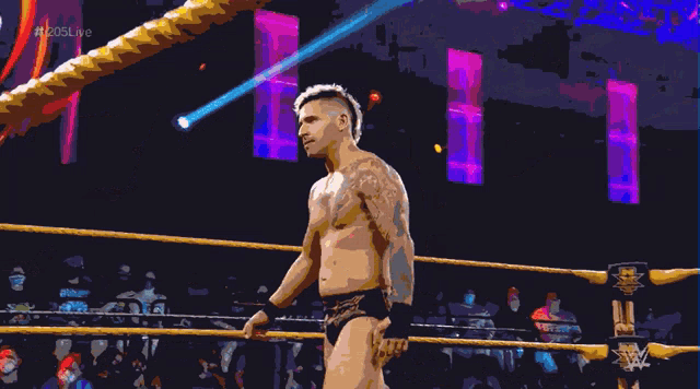 a man in a wrestling ring with a rope around his neck and a sign that says 205 live in the background