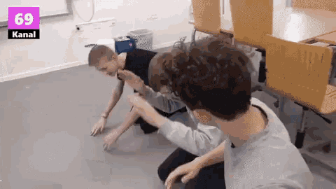 a group of young men are playing a game in a classroom with the number 69 kanal on the wall