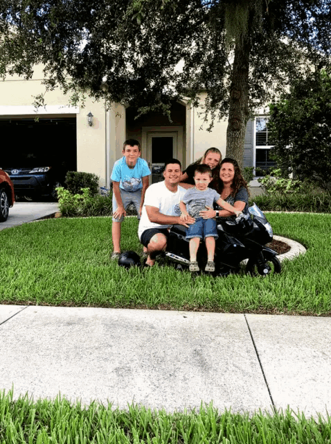 a family poses for a picture in front of their home