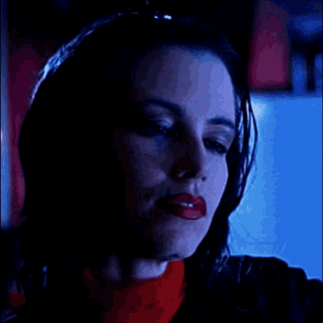 a close up of a woman 's face with red lips and black hair