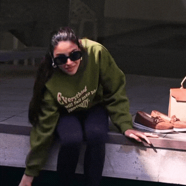 a woman wearing a green sweatshirt that says " everything will fall into place eventually "
