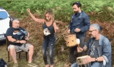 a man in a nike shirt is playing a bagpipe and a woman is dancing in the grass