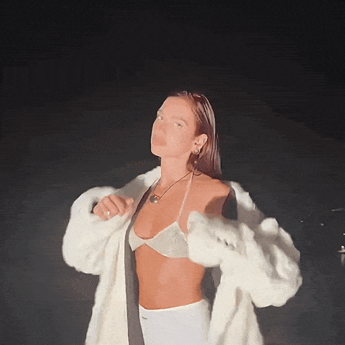 a woman wearing a bikini top and a fur coat