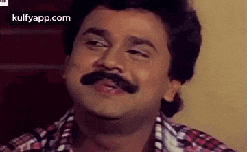 a man with a mustache is making a funny face with his eyes closed and his mouth open .
