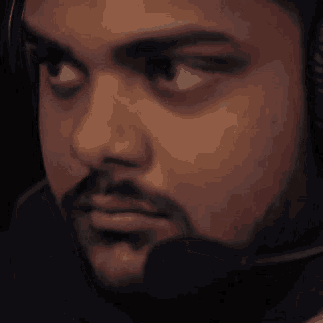 a man with a beard is wearing headphones and a microphone on his head .