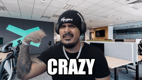 a man wearing headphones and a beanie with the word crazy written on it