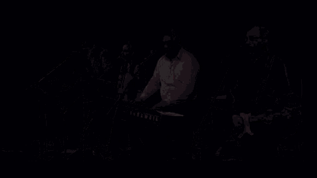 a group of people are playing instruments on a stage including a keyboard and a guitar .