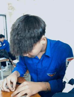 a boy in a blue shirt has a badge on his pocket that says ' a '