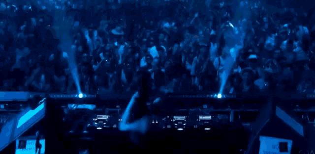a dj playing music in front of a crowd with a sign that says no touching