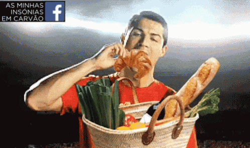 a man in a red shirt is holding a basket full of vegetables and bread
