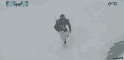 a football player is being tackled by another player in the snow