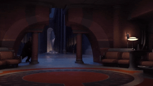 a man in a black robe stands in a room with columns
