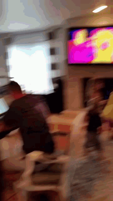a blurry photo of a man standing in front of a television