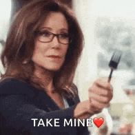 a woman is holding a fork in her hand and says take mine .
