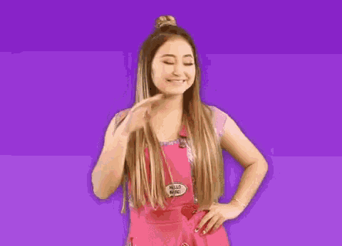 a woman in a pink apron with a hello babe pin on it