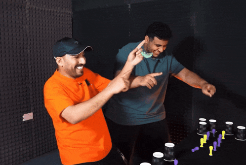 two men are playing a game and one is wearing an orange shirt that says m on it