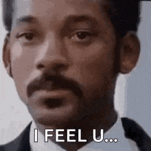 a man with a mustache is wearing a suit and tie and says `` i feel u '' .