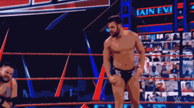 a man in a wrestling ring with a sign that says iain evi