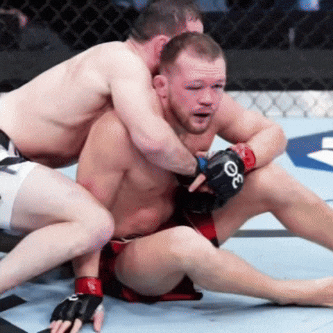 a man wearing a pair of gloves with the letter o on them is wrestling another man