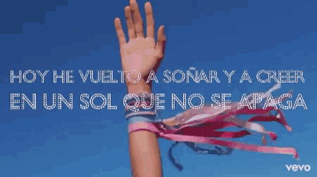 a woman holding a pink scarf in the air with the words hoy he vuelto a soñar