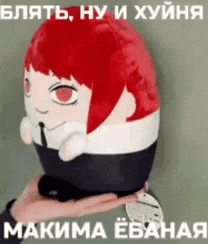 a person is holding a stuffed animal in their hand with a russian text behind it .