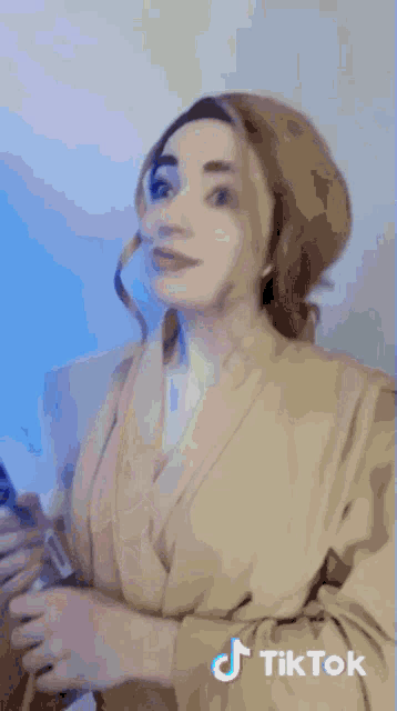 a woman is holding a blue light saber with tiktok written on the bottom of the image
