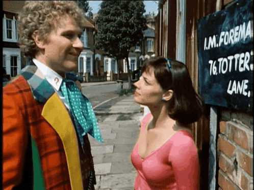 a man and woman are looking at each other in front of a sign that says i.m. foreign 76 totter lane
