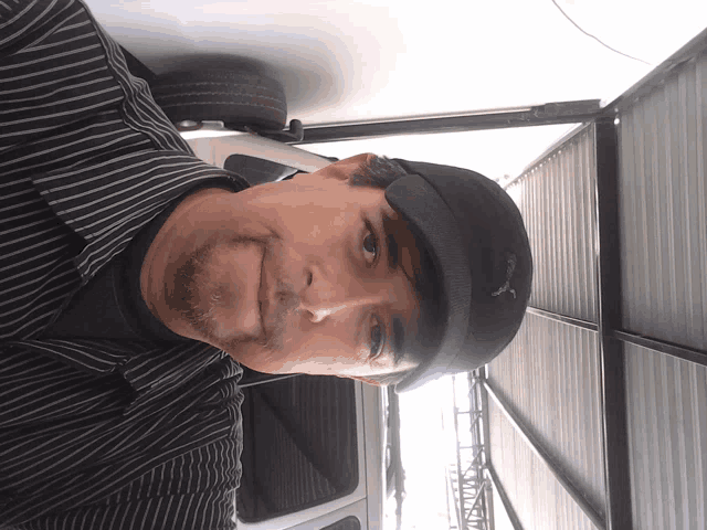 a man wearing a striped shirt and a nike hat