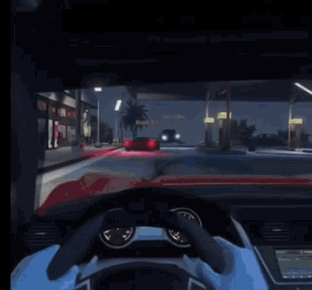 a car is driving down a street at night with a sign that says ' motel ' in the background