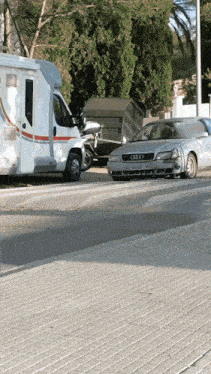 an audi car is parked on the side of the road next to a camper
