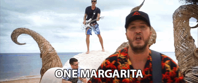 a man singing a song called one margarita on a beach