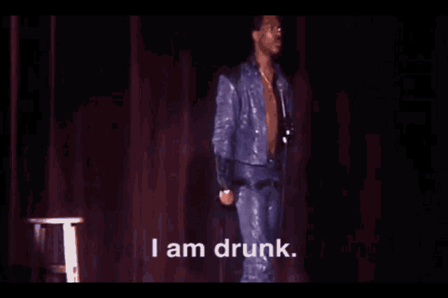 a shirtless man is standing on a stage with a microphone and the words " and you know something " behind him