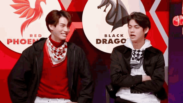 two men are standing next to each other in front of a sign that says black drago
