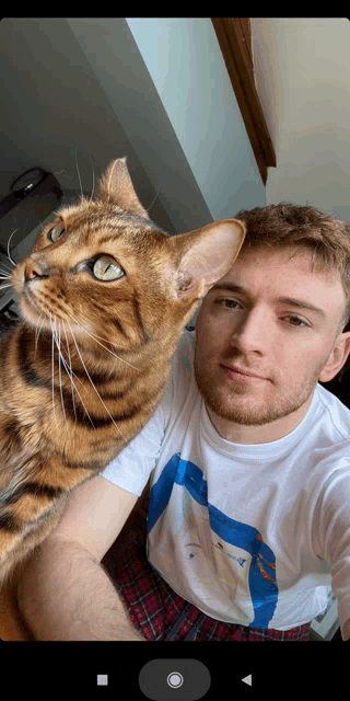 a man is holding a cat in his arms
