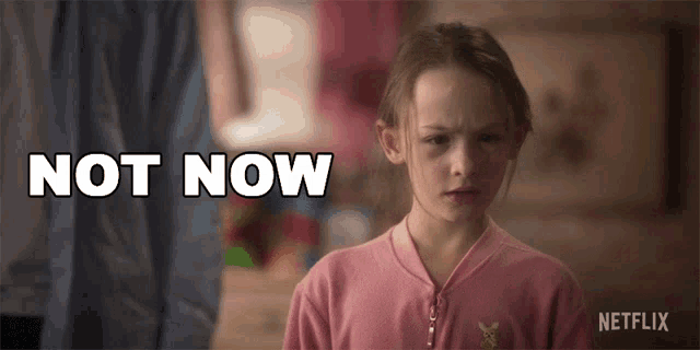 a girl in a pink sweater says not now