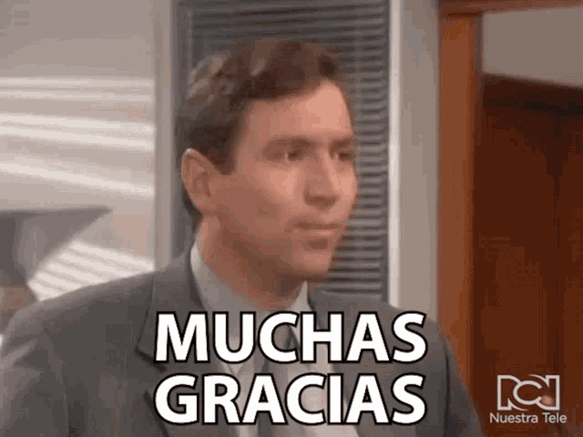 a man in a suit says muchas gracias on his face