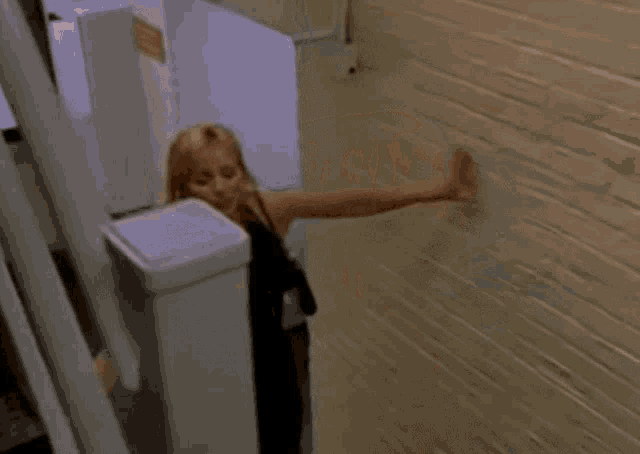 a woman in a black dress is screaming in a room .