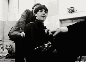 a black and white photo of two men sitting next to each other on a chair .