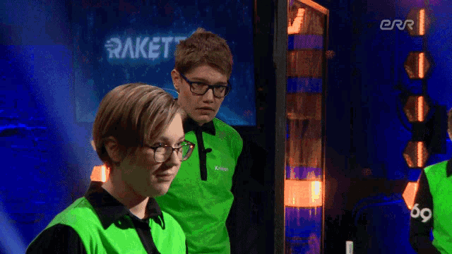 a man and a woman standing in front of a screen that says rakett