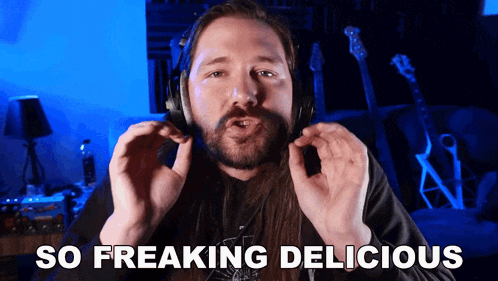 a man with long hair is wearing headphones and says so freaking delicious