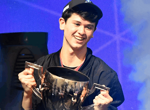 a man in a black hat is holding a trophy and smiling