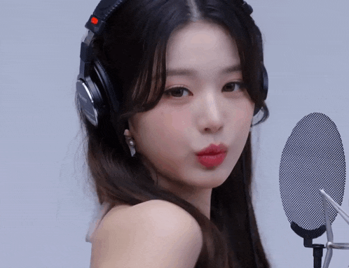 a woman wearing headphones and a microphone makes a funny face