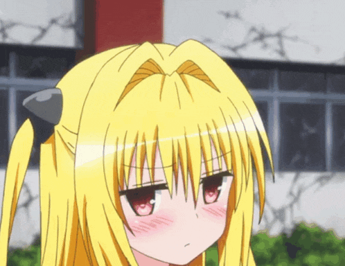 a girl with yellow hair and red eyes is making a face