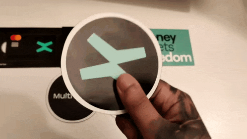 a person is holding a sticker that says " money gets freedom " on it