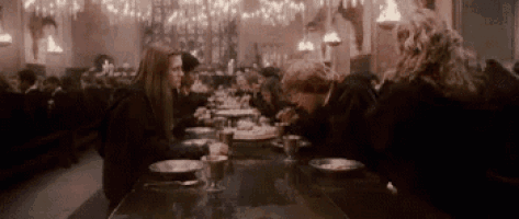 a group of people are sitting at a long table in a restaurant eating food .