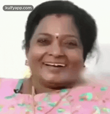 a close up of a woman 's face with a pink shirt on .